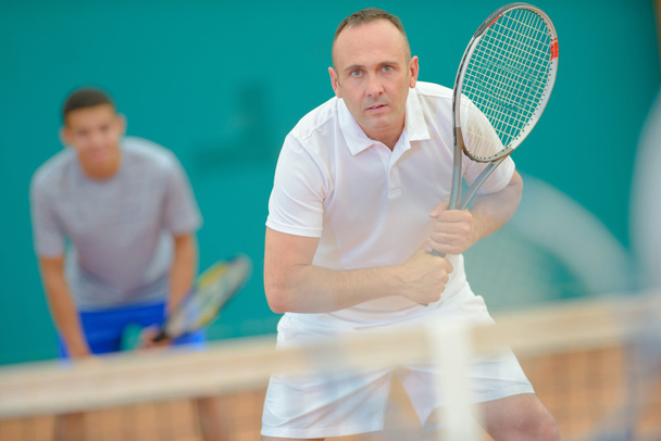 Men playing doubles tennis - Foto, afbeelding