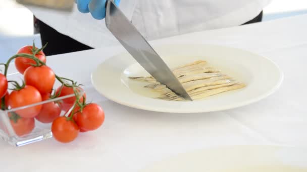 Cuisiner dans la cuisine avec un couteau dans un tartre de poisson et de tomates
 - Séquence, vidéo