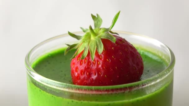 Rotating green pannacotta dessert with strawberry 4K macro video - Filmati, video