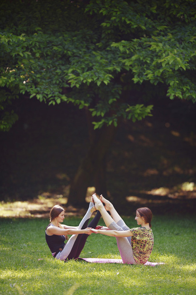 Jonge vrouw doen yoga oefeningen in park de brug. - Foto, afbeelding