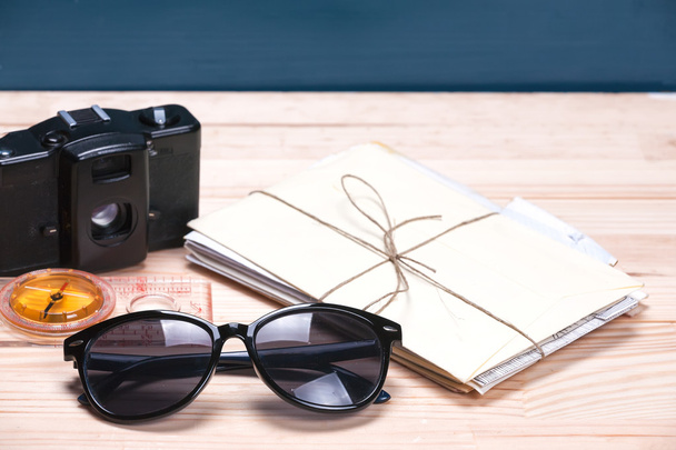 Солнечные очки, компас, старая кинокамера и буквы на
 - Фото, изображение