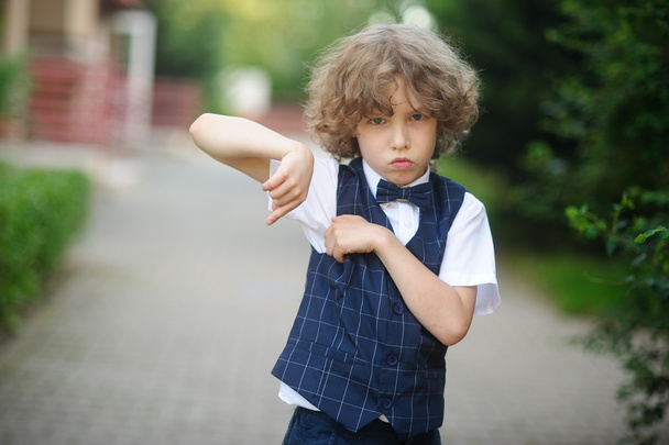 Little pupil is in the schoolyard with an angry expression on his face. - Photo, Image