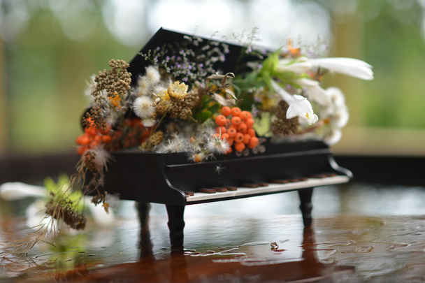 Сувенірне піаніно. Квіткова композиція на фортепіано
. - Фото, зображення