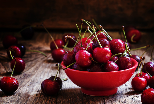 Red sweet cherries in a red bowl   - Fotó, kép