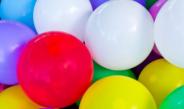 Un ballon rouge entre d'autres ballons colorés
 - Photo, image