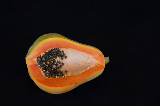 Ripe paw paw / papaya with seeds on black - Photo, Image