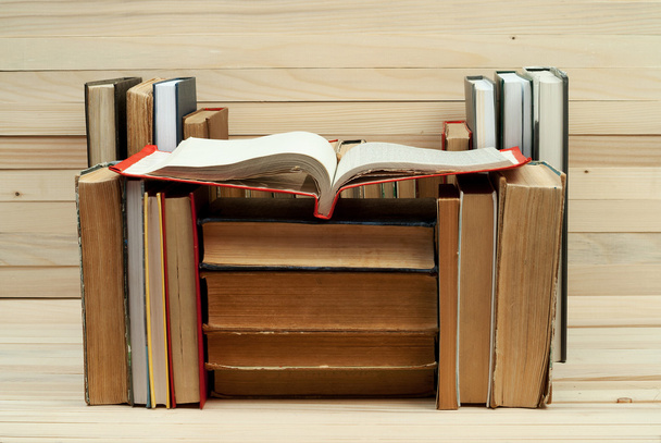 Hromada knih. Otevřená kniha, pevná vazba knihy na dřevěný stůl. Vědění je důležité. Kopírovat prostoru. Pohled shora - Fotografie, Obrázek