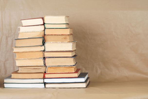 Oude en gebruikte hardback boeken of tekstboeken over houten tafel. Boek en het lezen zijn essentieel voor zelfverbetering, verkrijgen van kennis en succes in onze carrière, zakelijke en persoonlijke leven. Kopiëren van ruimte - Foto, afbeelding