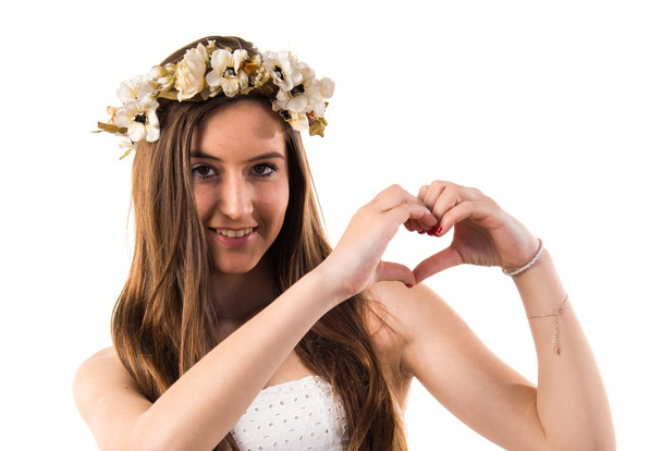 Chica con corona de flores haciendo un corazón con sus manos
 - Foto, imagen