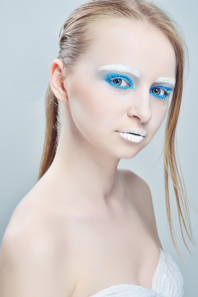 Jovem atraente aplicando bálsamo labial isolado em um fundo branco
 - Foto, Imagem