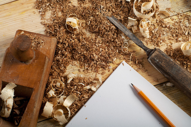 Folha branca na mesa de madeira para ferramentas de carpinteiro com serragem
. - Foto, Imagem