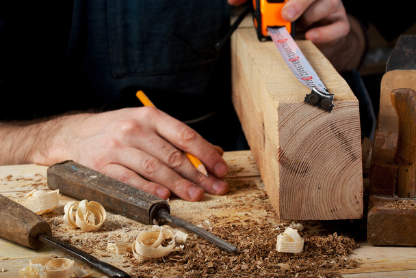 Carpinteiro trabalhando, martelo, medidor e chave de fenda no fundo da construção
 - Foto, Imagem