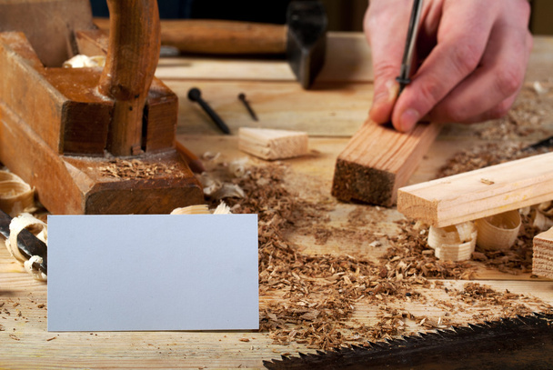Visitekaartje op houten tafel voor timmerman tools met zaagsel. - Foto, afbeelding