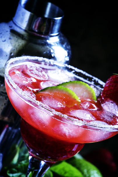 Alcoholic cocktail with strawberry, lime and ice - Фото, изображение