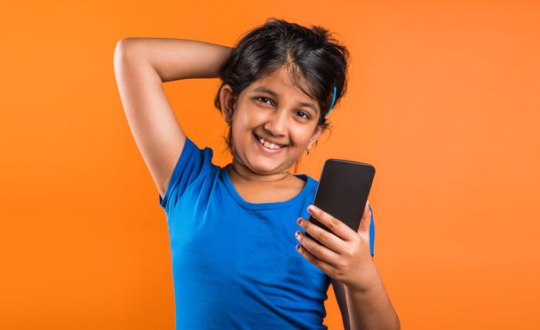 indisches kleines Mädchen mit Handy, asiatisches kleines Mädchen mit Handy, indisches Mädchen mit Kind und Handy, asiatisches Mädchen clild und mobil, indisches kleines Mädchen posiert mit Handy, indisches Mädchen spielt mit Handy, Selfie - Foto, Bild