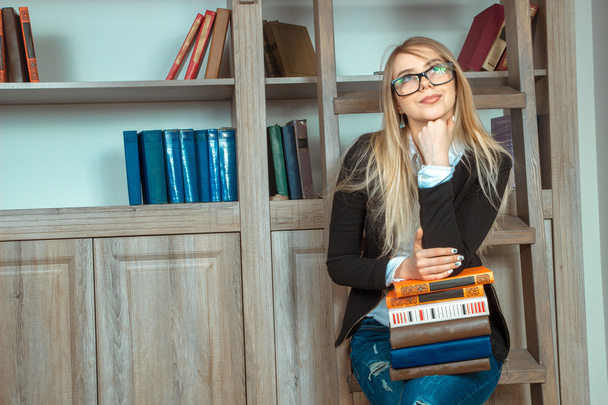 Interesting girl with a variety of books in the library - Foto, Bild