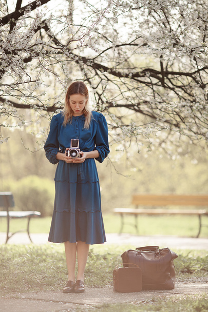 Young traveler in vintage blue dress leaves home for adventures. - Photo, image