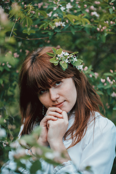 Portrait of beautiful young girl near blooming tree. Vintage concept - Foto, afbeelding