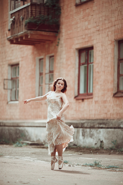 Young girl in beautiful dress and pointe shoes dancing on the st - Foto, Imagem