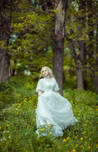 Beautiful blonde woman in blooming lilac garden. Vintage bride c - Foto, afbeelding