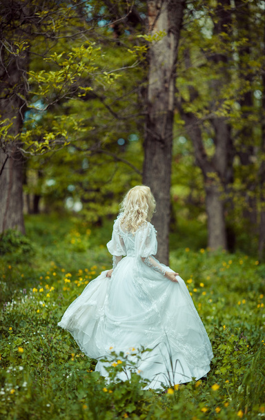 Beautiful blonde woman in blooming lilac garden. Vintage bride c - Fotó, kép