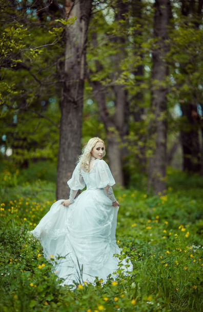 Beautiful blonde woman in blooming lilac garden. Vintage bride c - Foto, Imagen