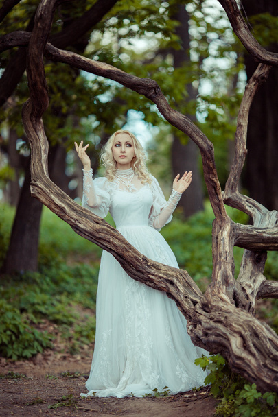 Beautiful blonde woman in blooming lilac garden. Vintage bride c - Photo, Image