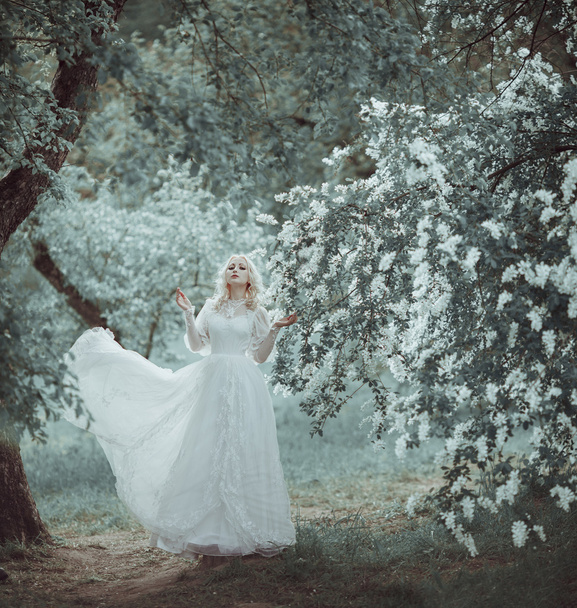 Beautiful blonde woman in blooming lilac garden. Vintage bride c - Фото, изображение