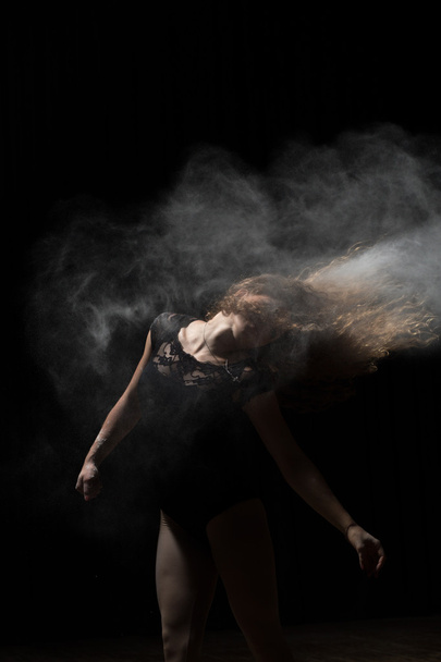 Woman dancing with flour in hair. Black background. - Фото, зображення