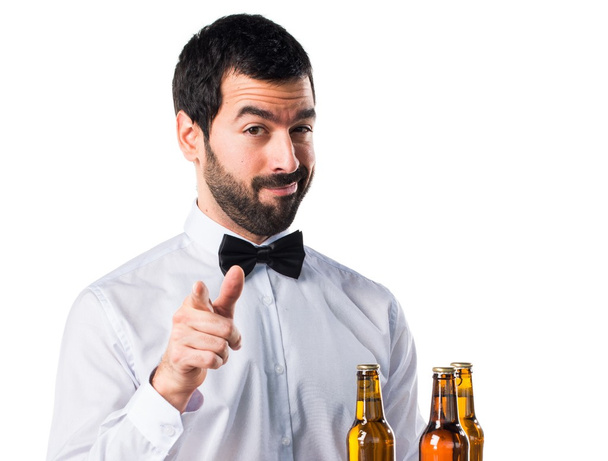 Офіціант з пляшками пива на лотку, що вказує на передній план
 - Фото, зображення