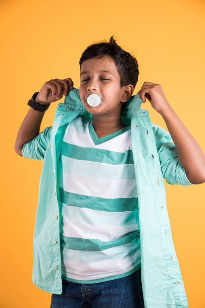 Ragazzo che soffia una bolla, ragazzo indiano che mastica gomma da masticare e fa un palloncino, ragazzo asiatico e gomma da masticare o gomma da masticare
 - Foto, immagini