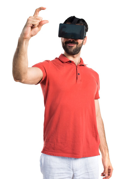 Handsome man using VR glassesa and holding something - 写真・画像