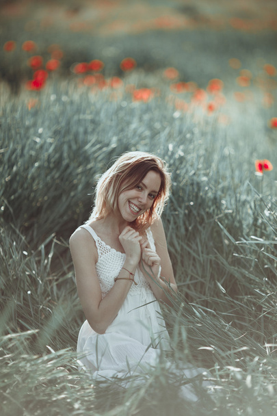 Красиві Українська дівчина з задоволенням в макового поля. - Фото, зображення