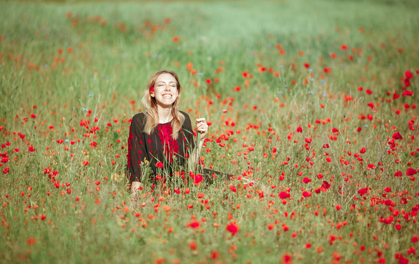 Beautiful ukrainian girl having fun in the poppy field. - Fotó, kép
