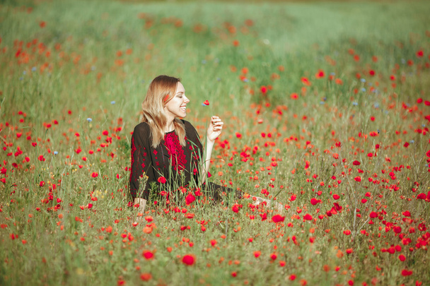 Beautiful ukrainian girl having fun in the poppy field. - Fotó, kép