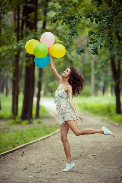 Beautiful young girl having fun at the summer park with colored balloons. Happy smile jump concept - Φωτογραφία, εικόνα