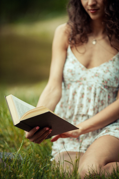 Yeşil çimenlerin üzerinde eğitim güzel genç kız. Kitap okuma - Fotoğraf, Görsel
