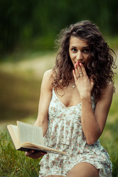 Όμορφη νεαρή κοπέλα που σπουδάζει στο πράσινο χορτάρι. Ανάγνωση βιβλίων - Φωτογραφία, εικόνα