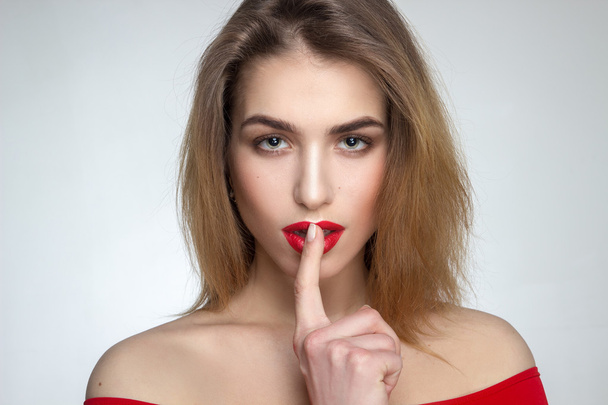 жінка з червоними губами і пальцем в роті
 - Фото, зображення