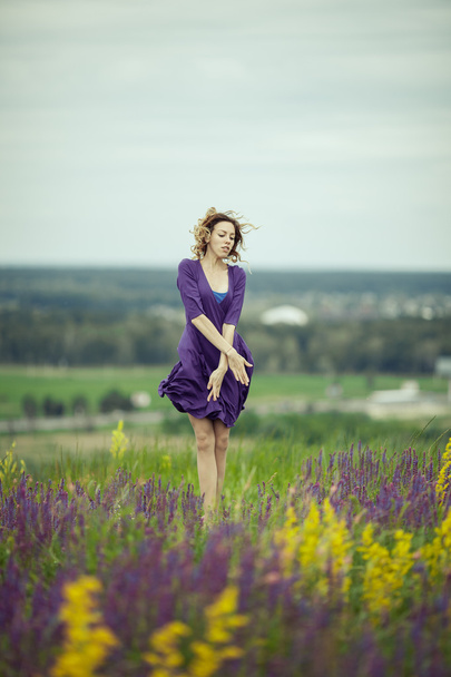 Mladá dívka v vintage šatech procházel sage flower pole. - Fotografie, Obrázek