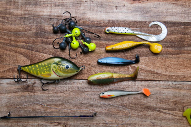 Fishing baits isolated on wooden background - 写真・画像