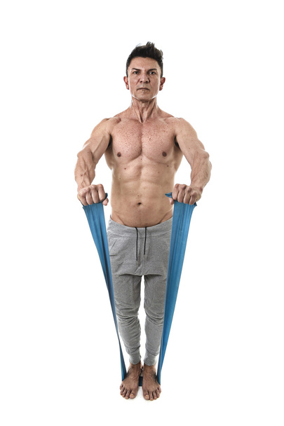 mature athletic sport man with bodybuilder strong and fit body training doing exercises with elastic rubber band - Foto, afbeelding
