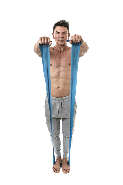 mature athletic sport man with bodybuilder strong and fit body training doing exercises with elastic rubber band - Zdjęcie, obraz