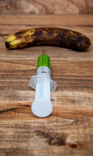 Overripe banana with a syringe - Photo, Image
