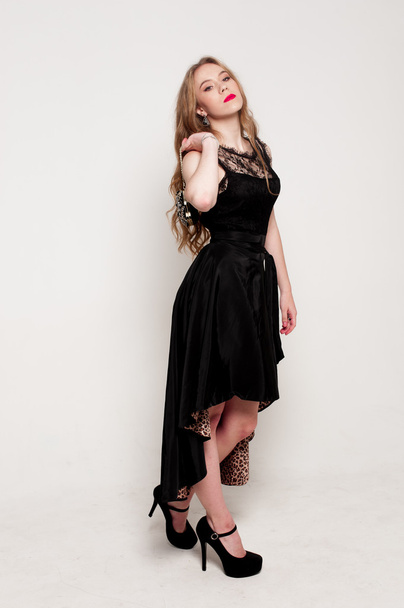 Portrait of beautiful young blonde girl in black dress. Fashion photo - Photo, Image