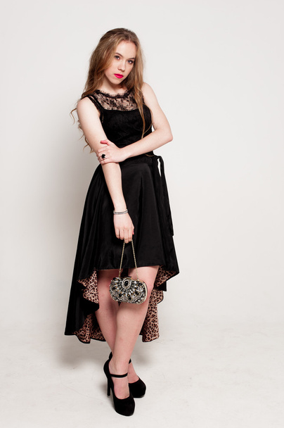 Portrait of beautiful young blonde girl in black dress. Fashion photo - Fotó, kép