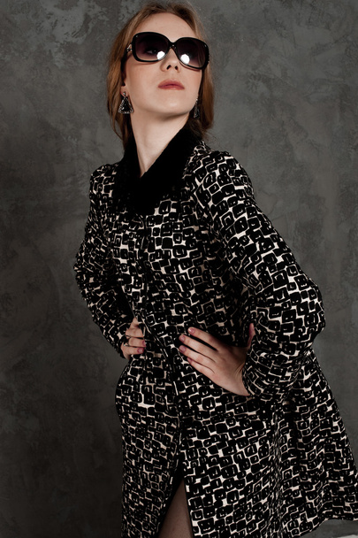 Fashion girl with handbag posing at the background weariing a coat - Valokuva, kuva