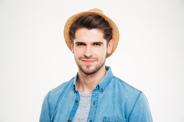 Closeup of confident young man in hat and blue shirt - Fotó, kép