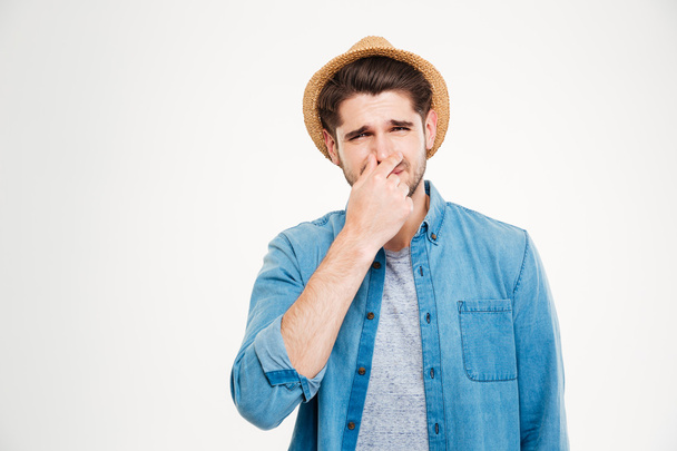 Upset man covered nose by hand and feeling bad smell - Foto, immagini