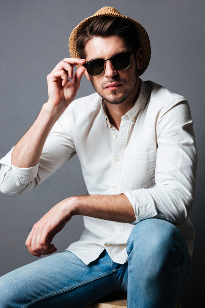 Fashion portrait of handsome young man in sunglasses and hat - Photo, image